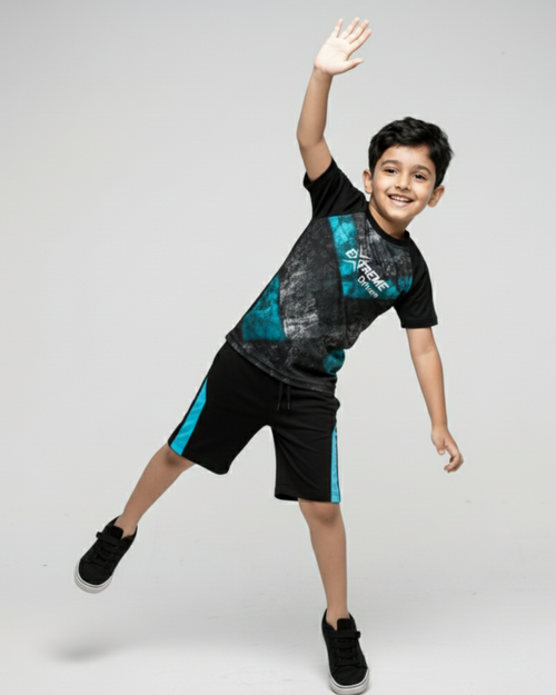Boy's wearing a black and teal outfit with a brand logo, waving on a light gray background