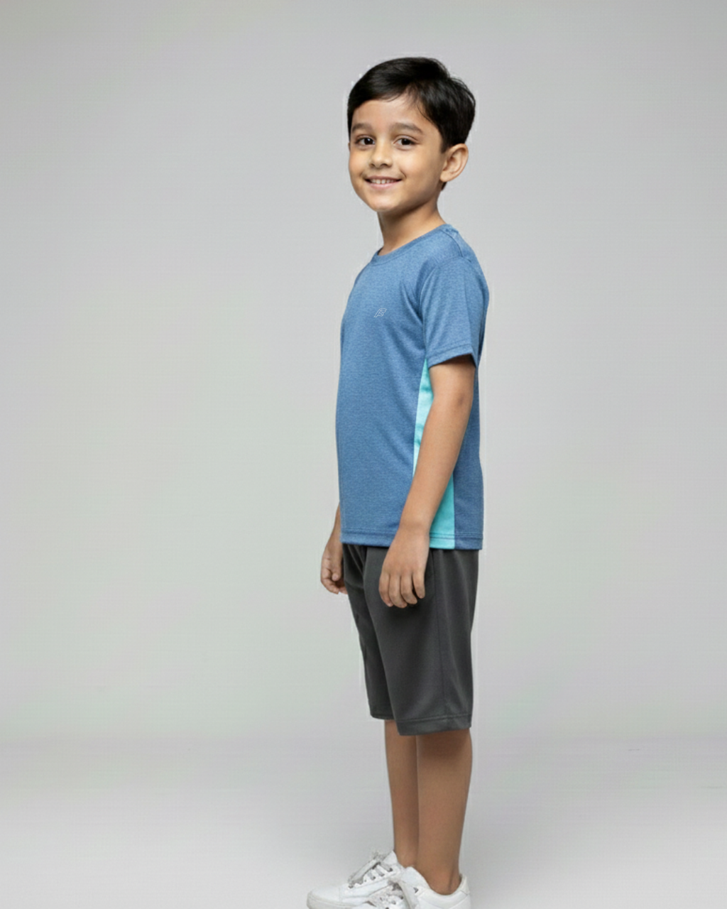 Boy Side View of  wearing a blue and gray outfit on a light gray background