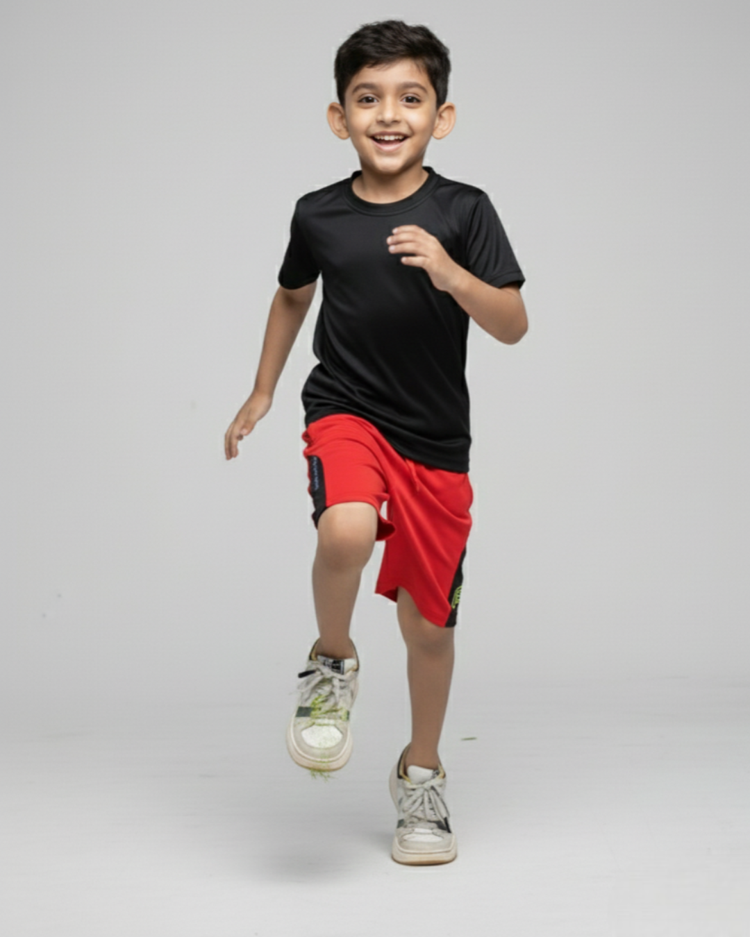 Boy's  wearing a black t-shirt and red shorts on a gray background